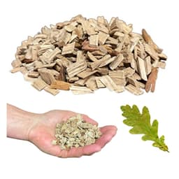 Pile of coarse oak wood chips for smoking, a handful in a palm and an oak leaf