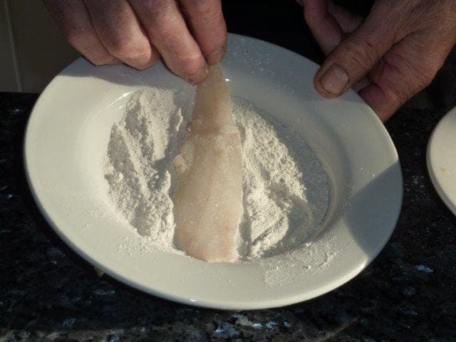 Put flour, beaten egg and breadcrumbs into three different shallow dishes. Take the first fish fillet and dip into the plain flour and then shake off any excess.