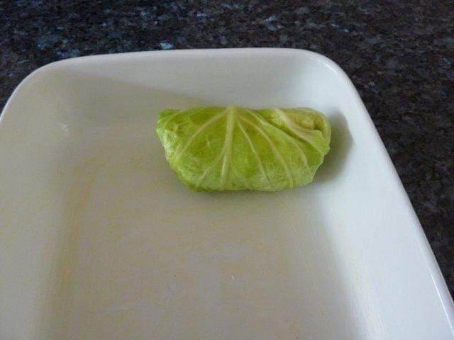 Turn in the sides of the cabbage leaf and then roll up and place into a greased oven proof dish with the seam underneath